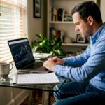 Man trading with AI system on home office laptop