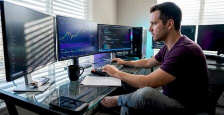 Man optimizing trading algorithms at desk
