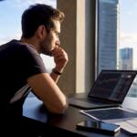 Retail trader at desk reviewing forex data