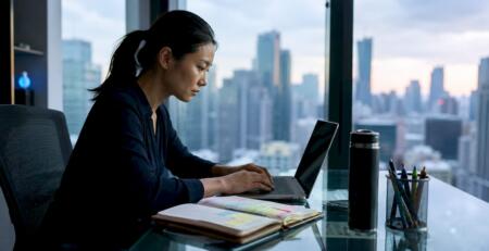 Woman trader reviewing forex charts at desk